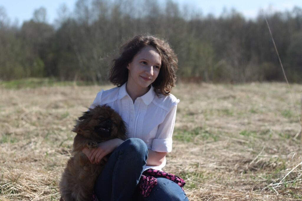 День открытых дверей в приюте: волонтёр с собачкой пекинесом на руках