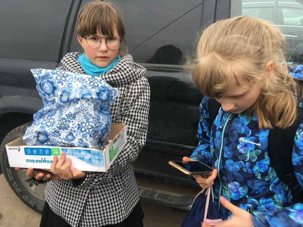 Две девочки в Лесколово держат коробку и пакет с найденными котятами, просят о помощи с передержкой