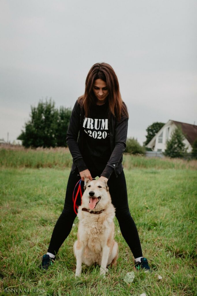 Девушка и собака на лугу.