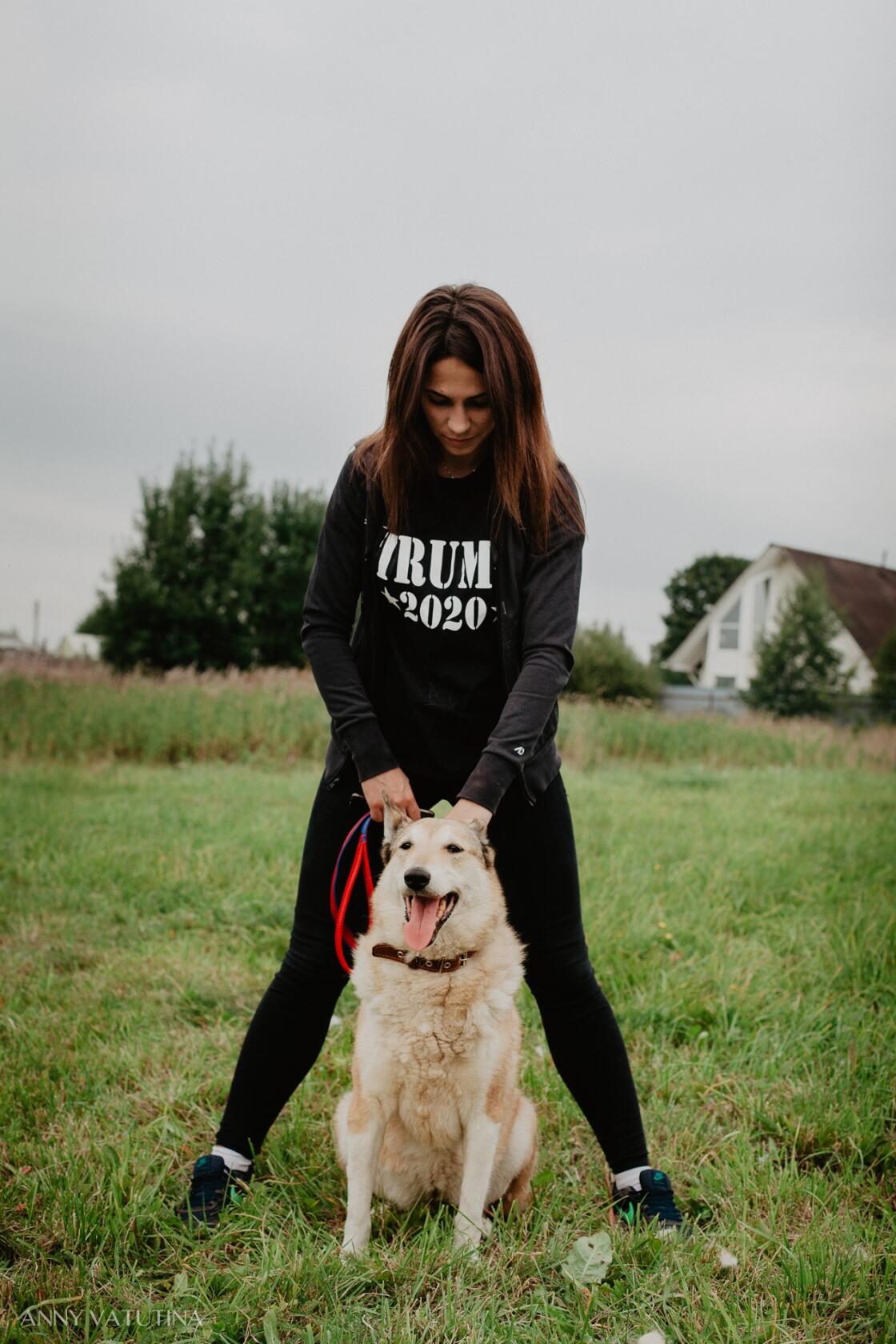 Девушка и собака на лугу.